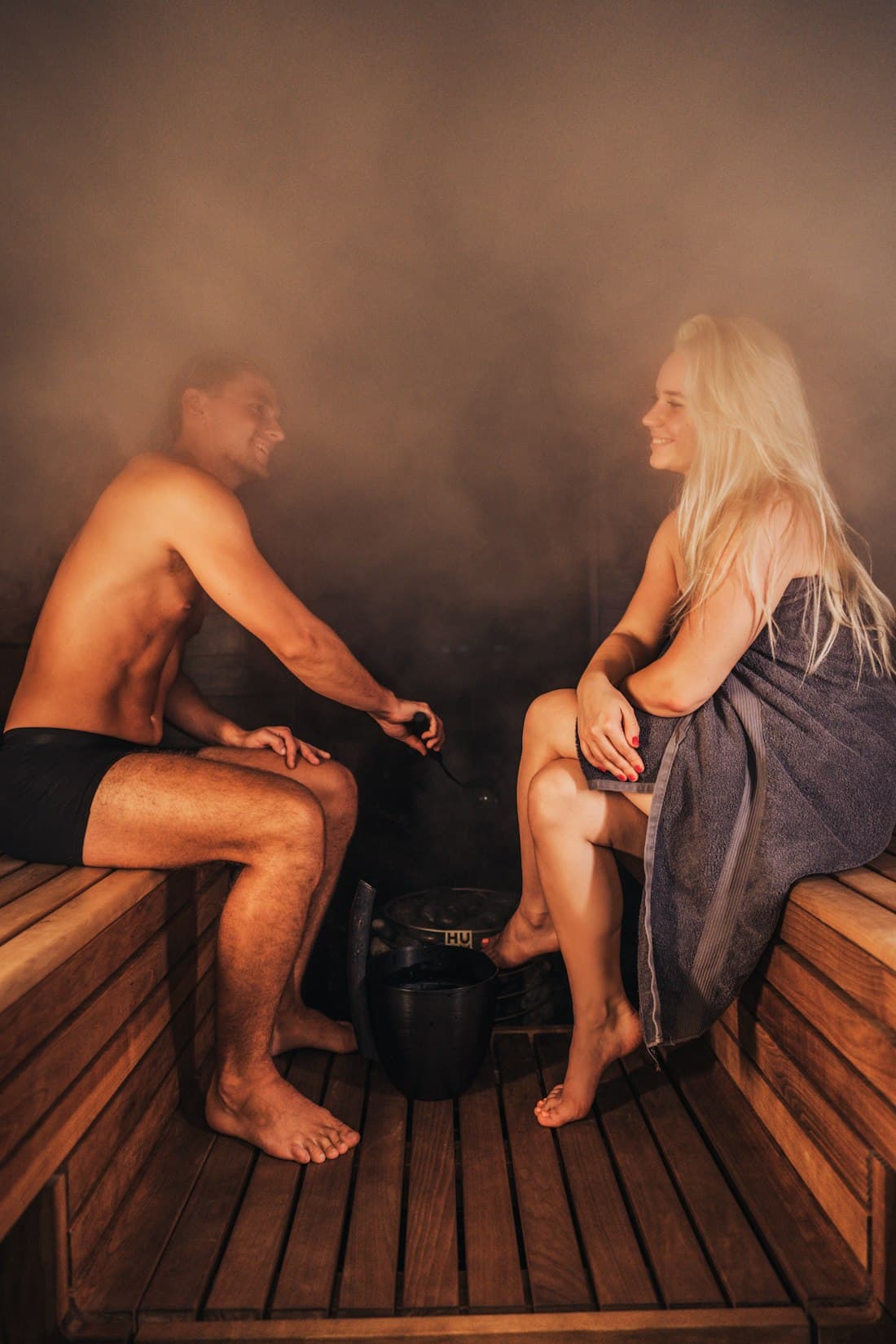 Two people relaxing together inside a warm cedar sauna