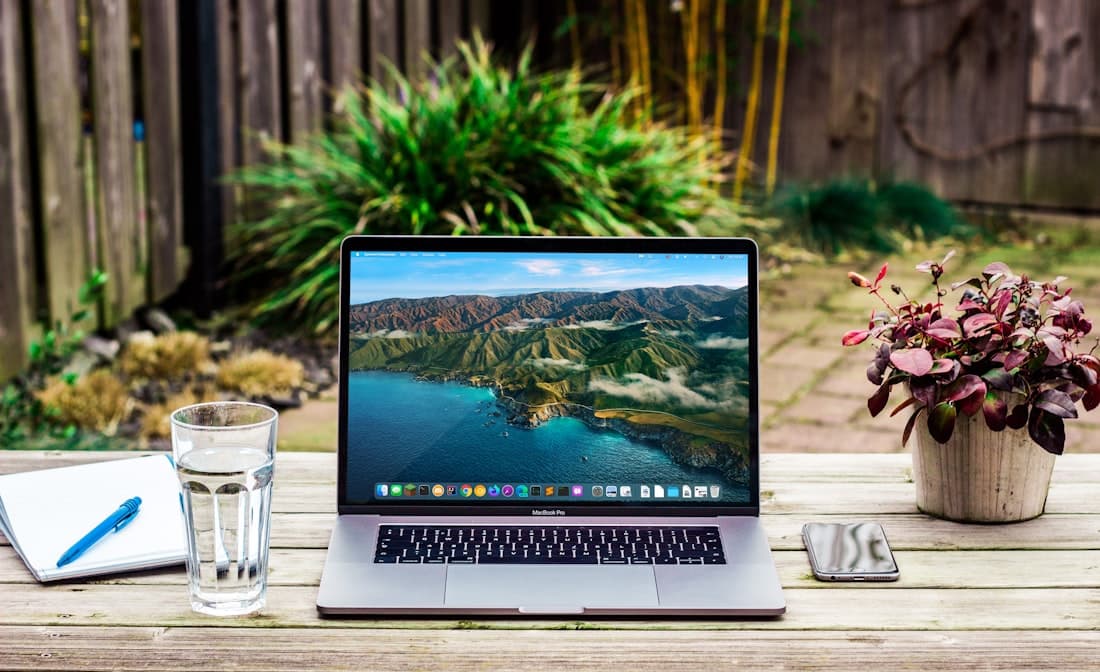 A laptop on a wood table showing the design for an outdoor space