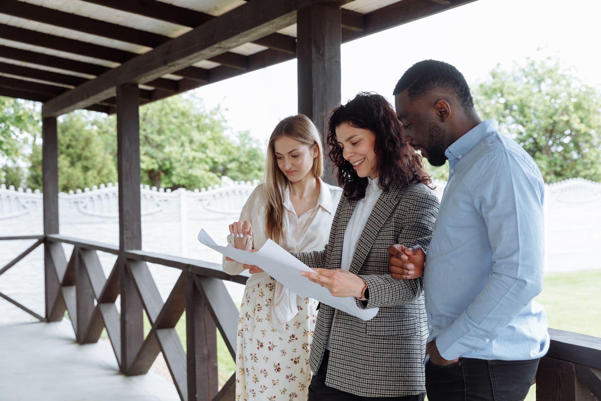 Our team reviewing plans with homeowners on their porch, yard behind them